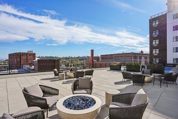 A patio with chairs and a fire pit with blue rocks.